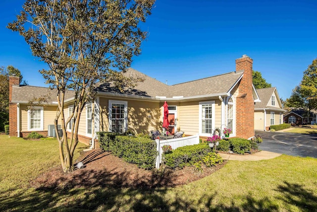 view of front of home featuring central AC and a front yard