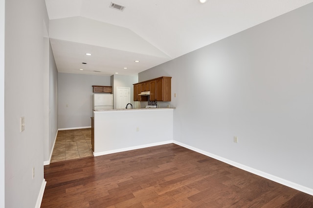 unfurnished living room featuring dark wood-type flooring and vaulted ceiling