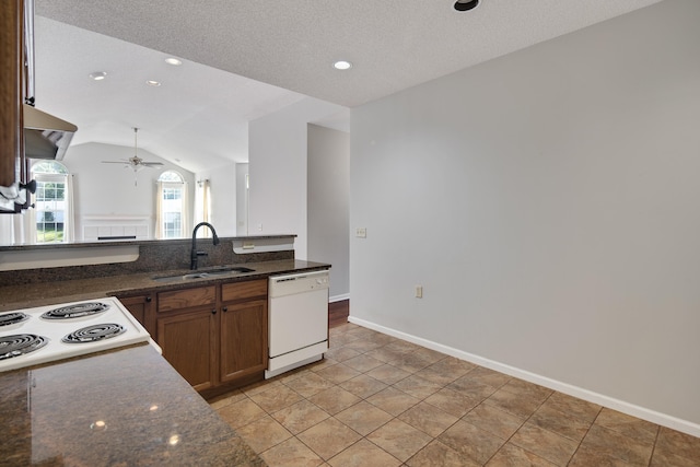 kitchen featuring dark stone counters, white dishwasher, vaulted ceiling, sink, and ceiling fan