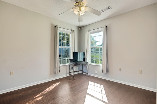 empty room featuring dark wood-type flooring, a textured ceiling, and ceiling fan