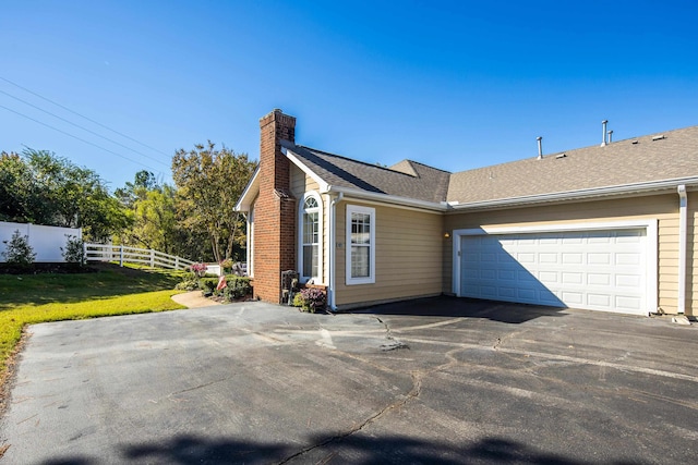 view of home's exterior featuring a garage and a yard