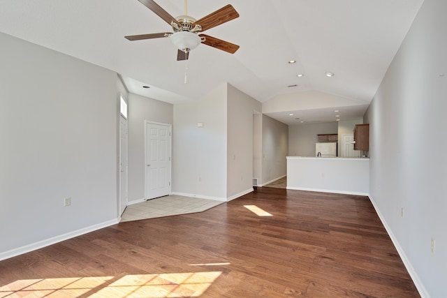 unfurnished living room with vaulted ceiling, hardwood / wood-style flooring, and ceiling fan