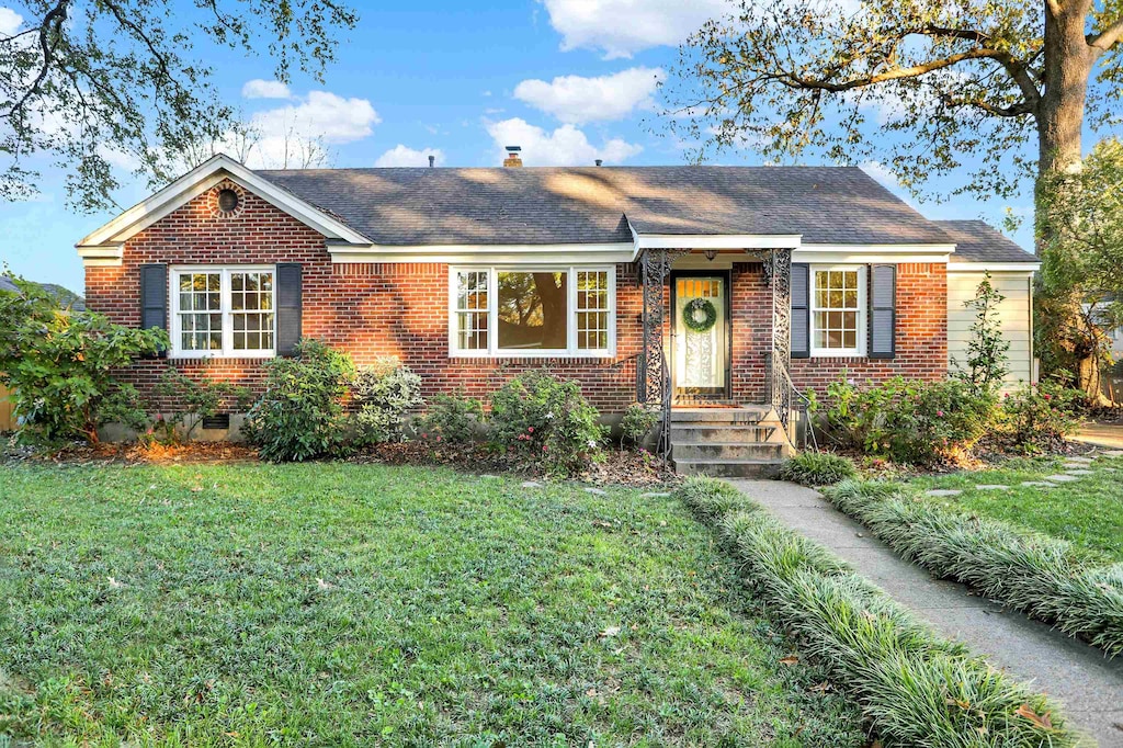 ranch-style home featuring a front lawn