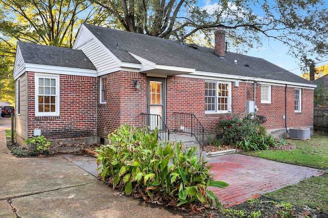 rear view of house with central AC and a patio