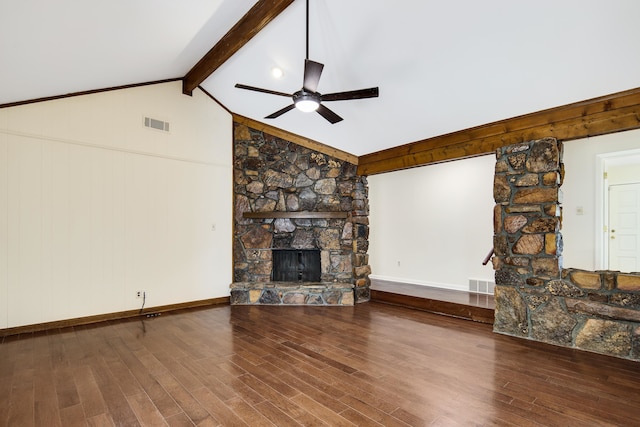 unfurnished living room with hardwood / wood-style flooring, vaulted ceiling with beams, and a stone fireplace