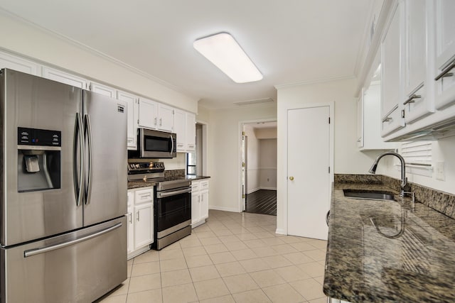 kitchen featuring crown molding, dark stone counters, stainless steel appliances, sink, and white cabinets