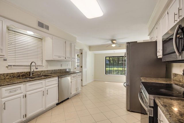 kitchen featuring ornamental molding, stainless steel appliances, white cabinetry, sink, and ceiling fan