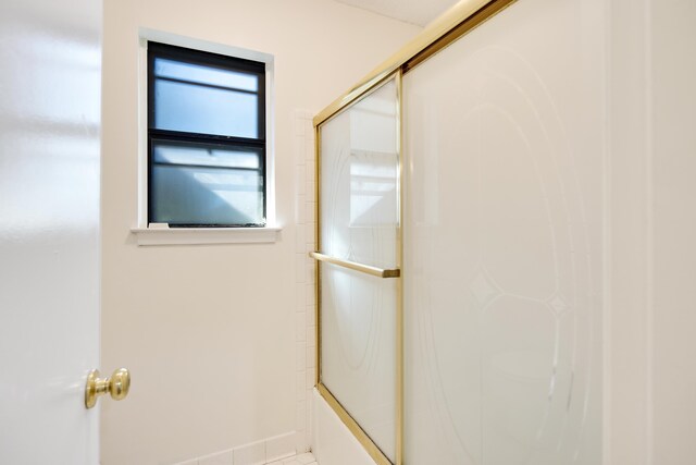 bathroom with shower / bath combination with glass door