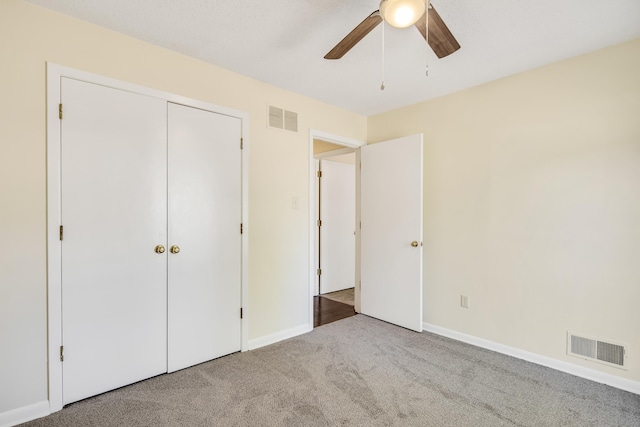 unfurnished bedroom featuring carpet floors, ceiling fan, and a closet