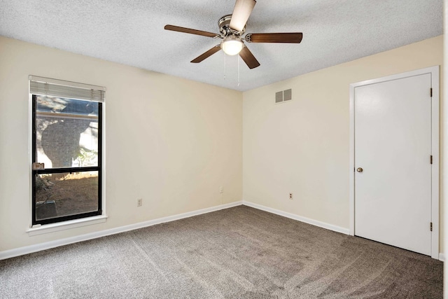 empty room with ceiling fan, a textured ceiling, and carpet floors