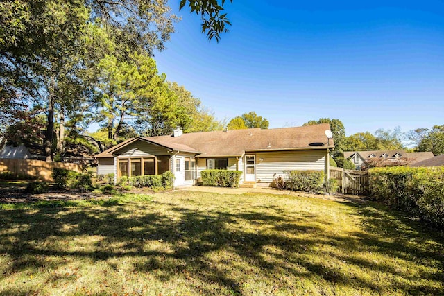 back of house featuring a sunroom and a yard