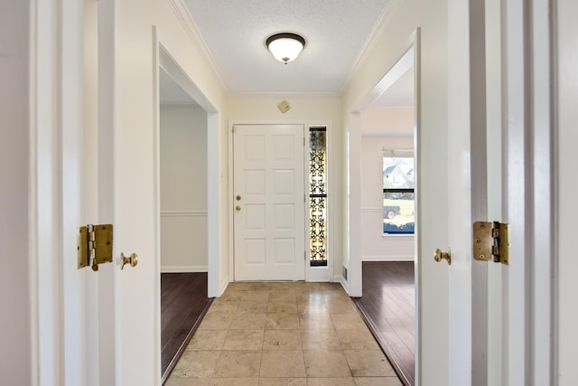 entrance foyer featuring light hardwood / wood-style floors, a textured ceiling, and ornamental molding