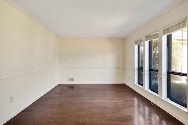 spare room featuring ornamental molding, dark hardwood / wood-style flooring, and a textured ceiling