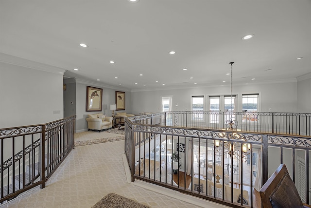 hallway featuring light colored carpet, crown molding, and an inviting chandelier