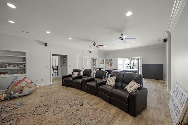 home theater room with ceiling fan, light wood-type flooring, and crown molding