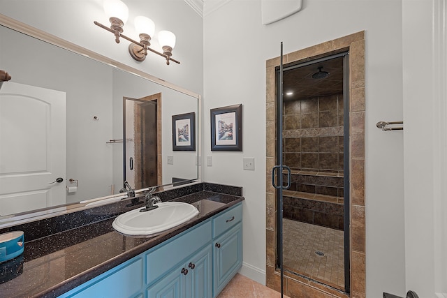 bathroom with a shower with shower door, vanity, tile patterned floors, and crown molding