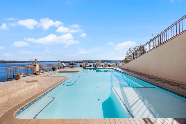 view of pool with a water view and a patio area