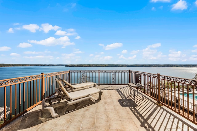 view of patio with a water view and a balcony