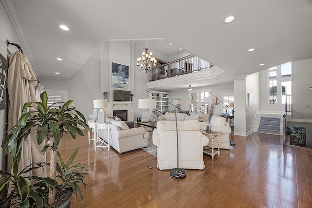 living room featuring a chandelier, wood-type flooring, and crown molding