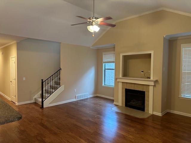 unfurnished living room featuring ceiling fan, dark hardwood / wood-style floors, crown molding, and vaulted ceiling