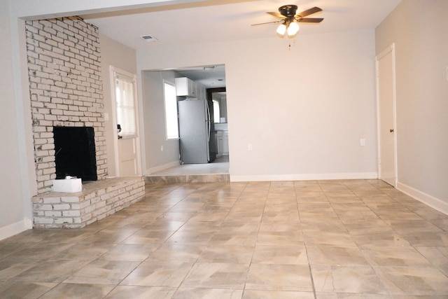 unfurnished living room with ceiling fan and a fireplace