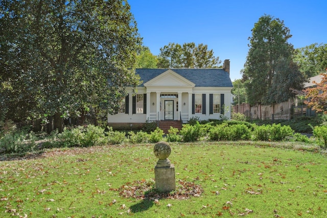 greek revival inspired property featuring a front lawn