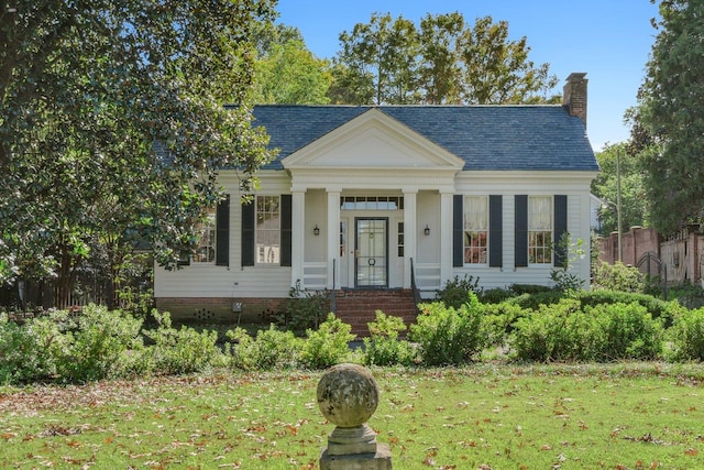 neoclassical / greek revival house featuring a front lawn