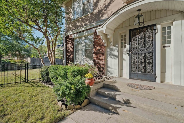 property entrance featuring a lawn