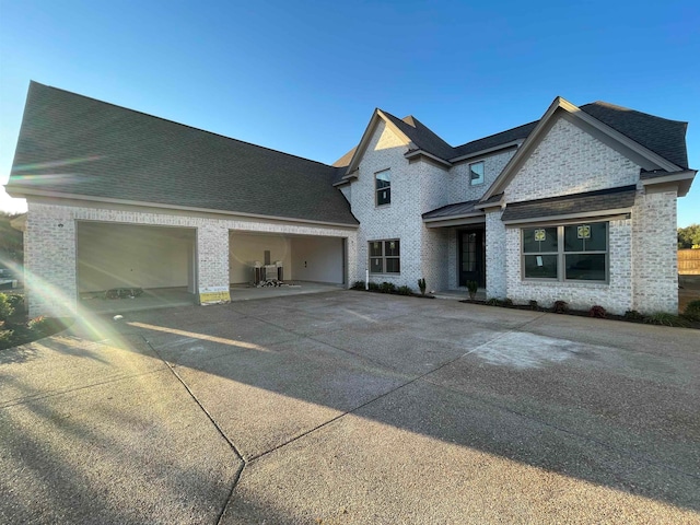 view of side of property featuring central AC unit and a garage