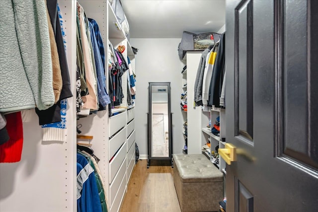 walk in closet with light hardwood / wood-style flooring