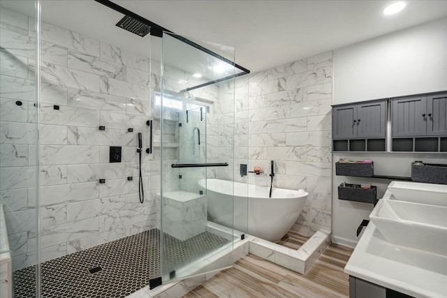 bathroom with tile walls, vanity, hardwood / wood-style flooring, and separate shower and tub