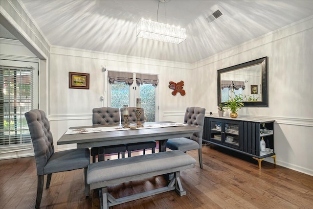 dining area with an inviting chandelier, hardwood / wood-style flooring, and crown molding