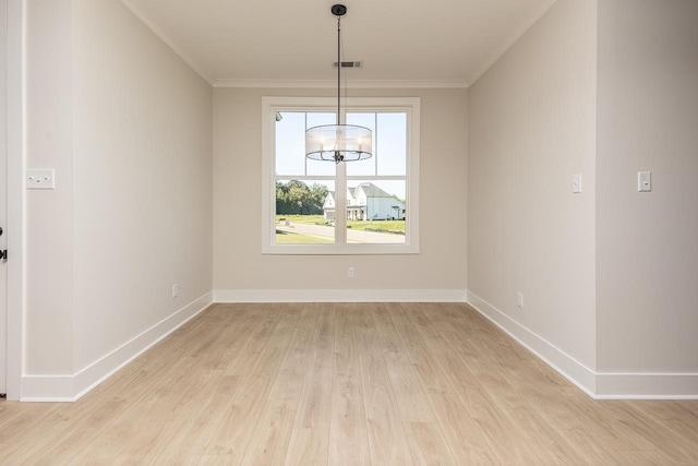 unfurnished dining area featuring crown molding, light hardwood / wood-style floors, and an inviting chandelier