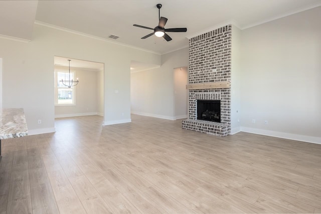 unfurnished living room featuring a fireplace, ceiling fan with notable chandelier, ornamental molding, and light hardwood / wood-style floors