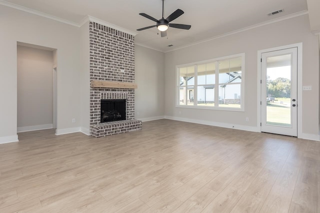 unfurnished living room with ceiling fan, ornamental molding, light hardwood / wood-style floors, and a brick fireplace