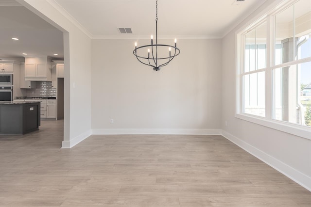 unfurnished dining area with ornamental molding, a notable chandelier, and light wood-type flooring