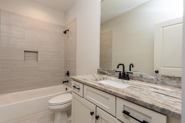 full bathroom with vanity, tiled shower / bath combo, and toilet