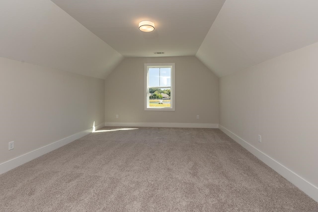 bonus room with carpet floors and vaulted ceiling