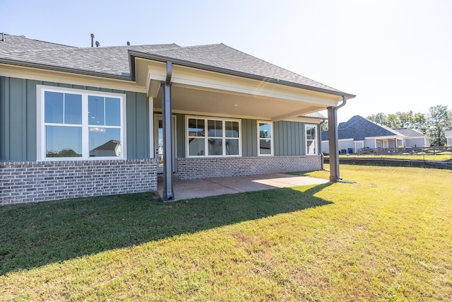 rear view of property featuring a lawn and a patio area