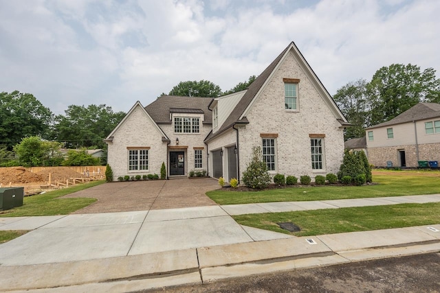 view of front of home with a garage and a front lawn