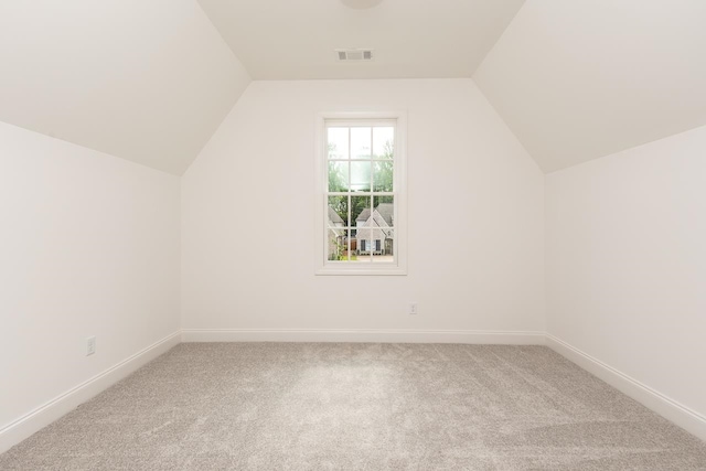 additional living space with carpet floors and vaulted ceiling