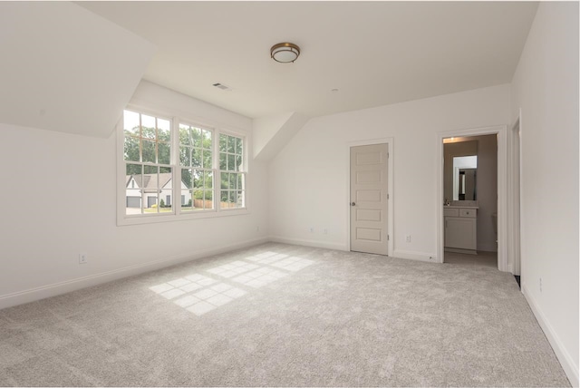 unfurnished bedroom featuring light carpet and vaulted ceiling