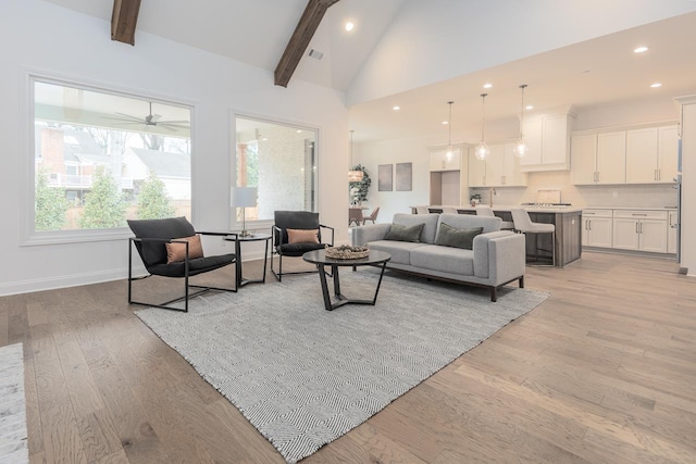 living room featuring high vaulted ceiling, beamed ceiling, and light wood-type flooring