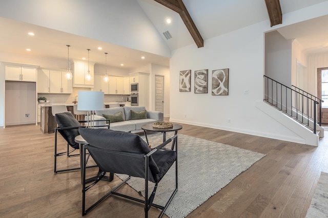 living room featuring beamed ceiling, light hardwood / wood-style floors, and high vaulted ceiling