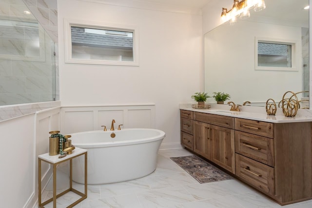 bathroom with vanity, ornamental molding, and a tub