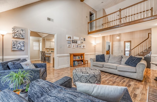 living room featuring light wood-type flooring and high vaulted ceiling