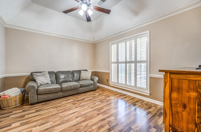 living room featuring crown molding, ceiling fan, a textured ceiling, and light wood-type flooring