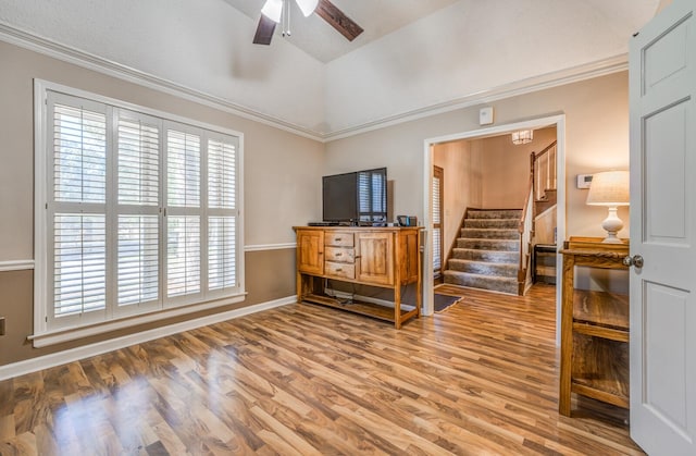 living room with ceiling fan, crown molding, light hardwood / wood-style floors, and lofted ceiling