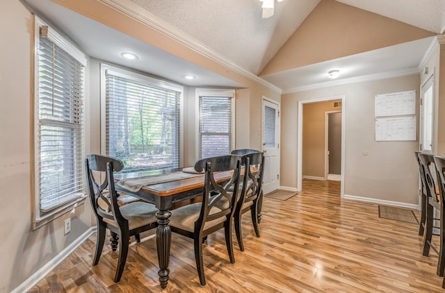 dining area with crown molding, ceiling fan, light hardwood / wood-style floors, and lofted ceiling