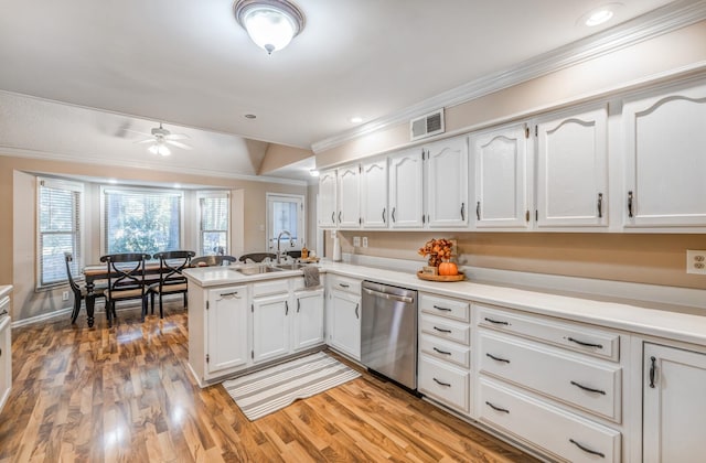 kitchen featuring kitchen peninsula, stainless steel dishwasher, sink, light hardwood / wood-style flooring, and white cabinetry